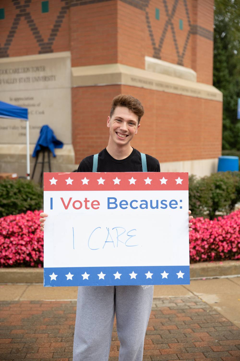 Student holding sign titled "I vote because: I care"